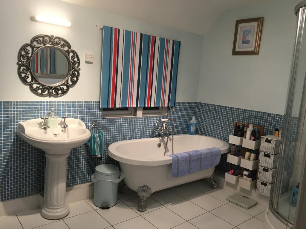 A bathroom with roll-top bath at Halzephron House
