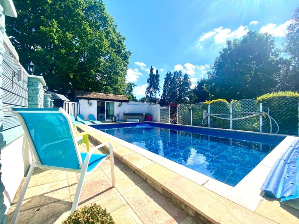 Outdoor swimming pool with loungers in Halzephron House's garden